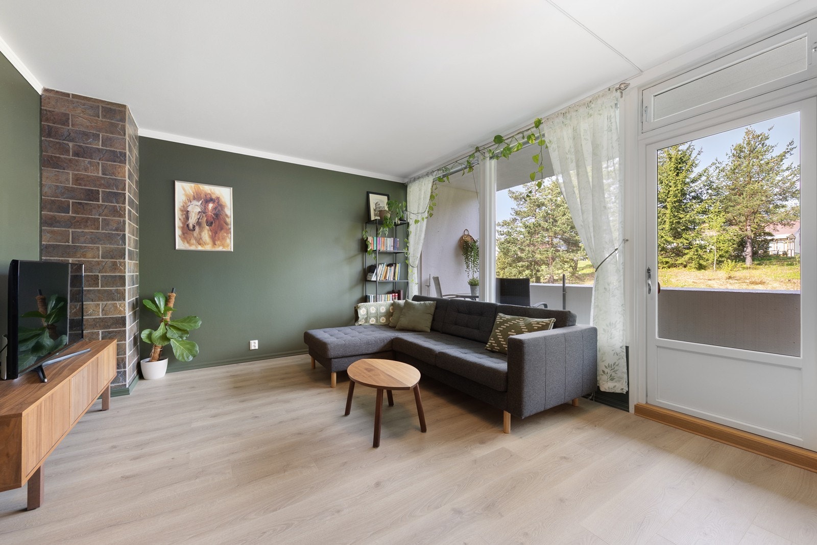 Stuen har store vindusflater som gir godt med lys, og her er det plass til både sofagruppe og spisebord. Galleribilde