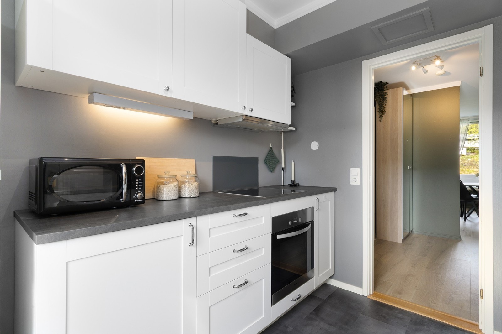 Kjøkkeninnredningen fra Ikea har hvite, glatte fronter og en slitesterk laminatbenkeplate. Galleribilde