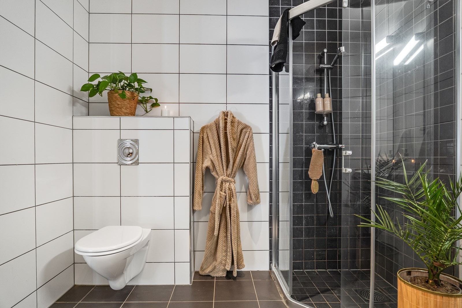 Badet er utstyrt med vegghengt toalett og har fliser på veggene. Galleribilde
