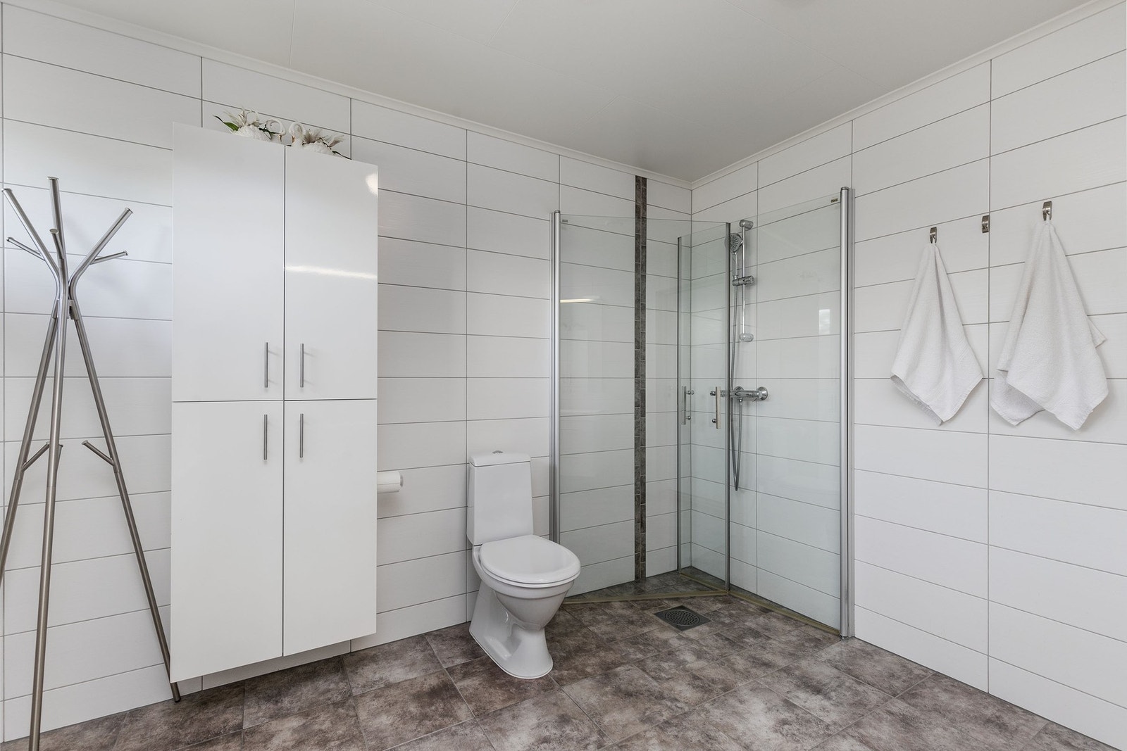 Badet er utstyrt med både badekar, dusjvegger og vegghengt toalett. Galleribilde