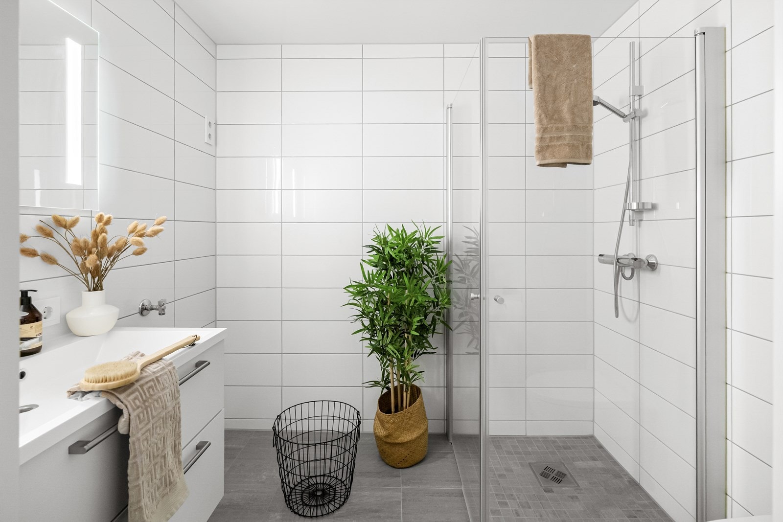 Badet er innredet med servant i baderomsmøbel, dusjhjørne, vegghengt toalett og har opplegg for vaskemaskin. Galleribilde