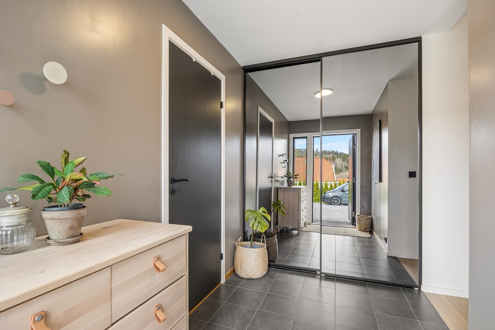 Velkommen inn i en romslig entrè med skyvedørs garderobe. Fliser på gulv. Galleribilde