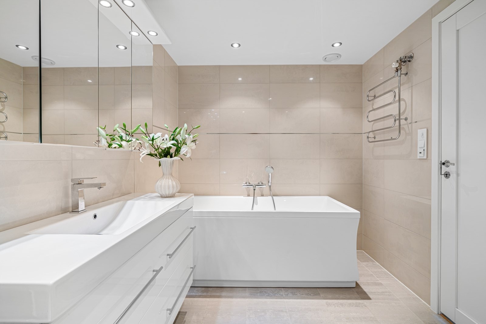 - Badet måler 7,2m² og er innredet med romslig servantmøbel, speilskap, vegghengt toalett, dusjhjørne med innfellbare glassdører og badekar - Galleribilde
