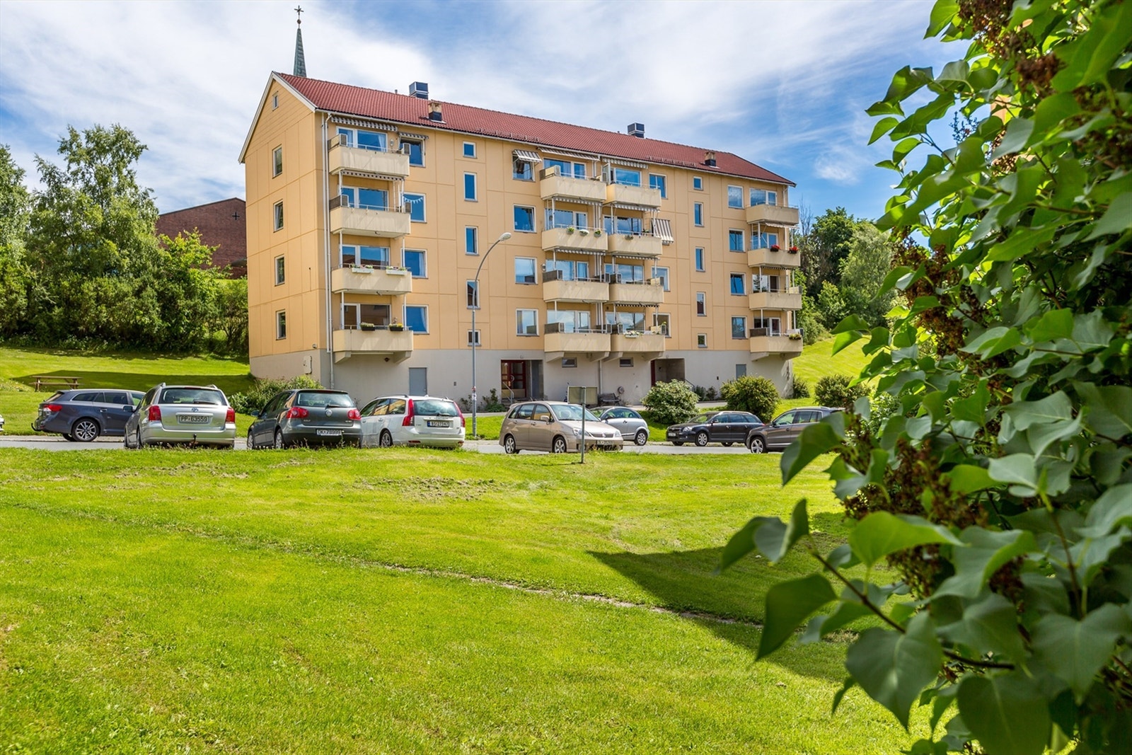 Blokken er omkranset av grøntareal og borettslaget har to fine møteplasser med lekestativ og benker Galleribilde