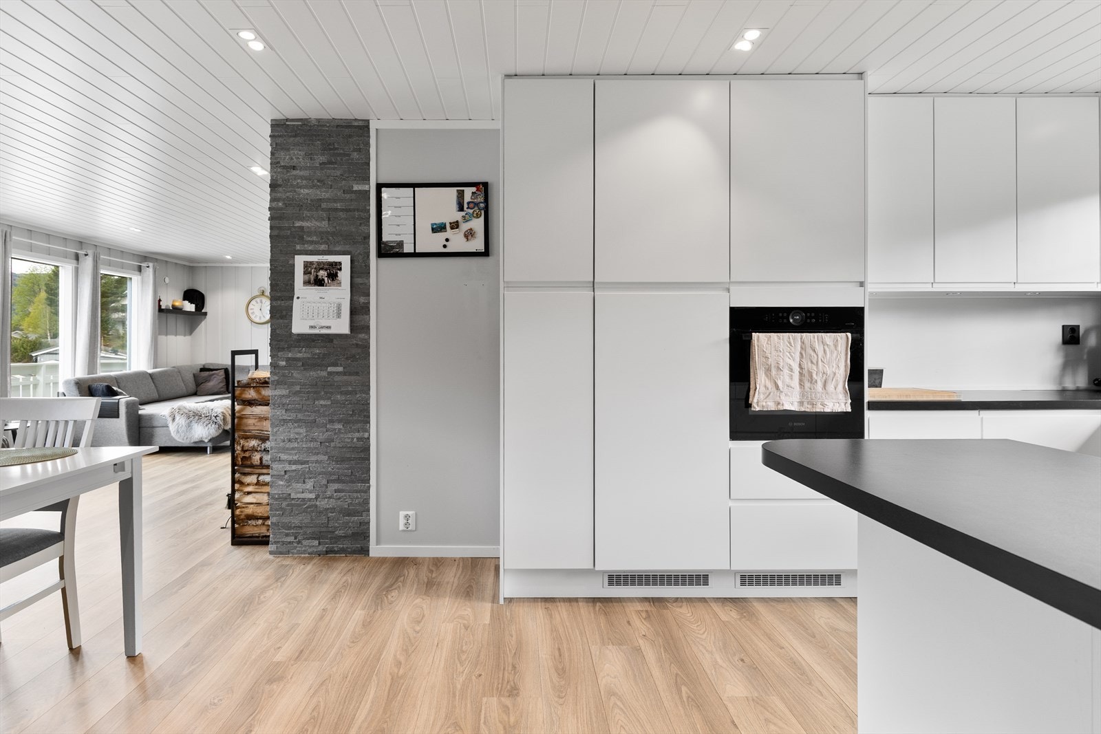 Den delvis åpne løsningen mellom kjøkken og stue skaper en sosial og luftig atmosfære. Galleribilde