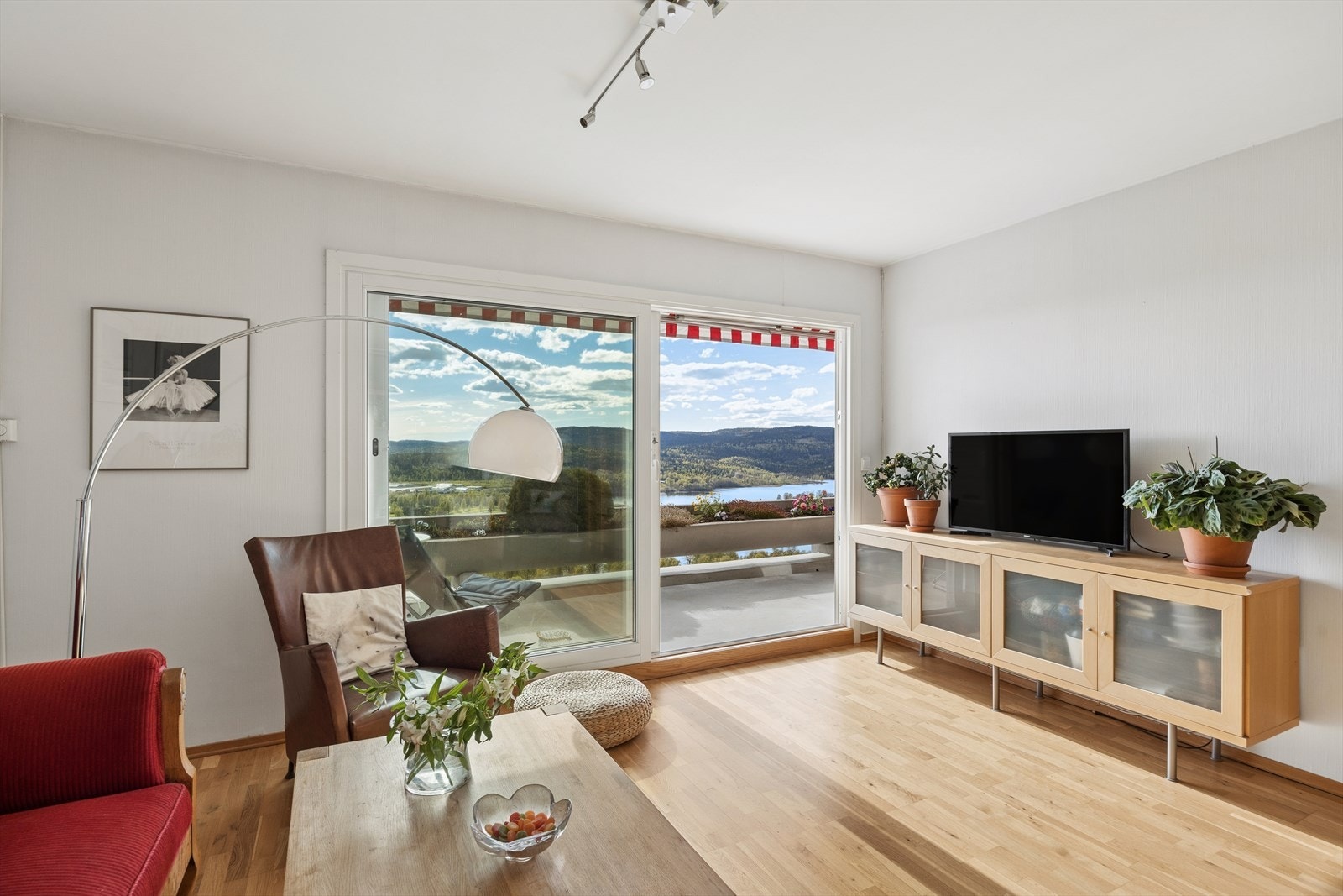 Store vindusflater og utgang til en sydvestvendt terrasse. Her kan man også nyte utsikten fra sofakroken Galleribilde