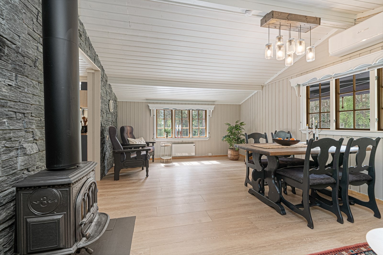 Stuen har god plass til både spisebord og sofagruppe, og oppvarmes effektivt med både vedovn og luft-til-luft varmepumpe. Galleribilde