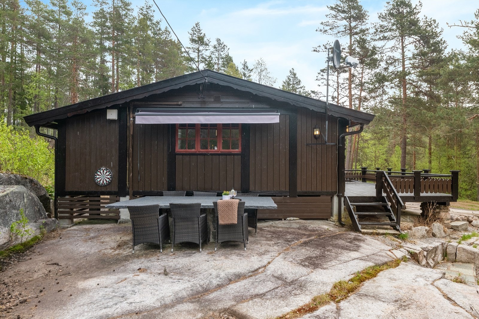 Tomten er en festet naturtomt med fjell i dagen, omgitt av furuskog. Uteområdet er opparbeidet med treterrasser. Galleribilde