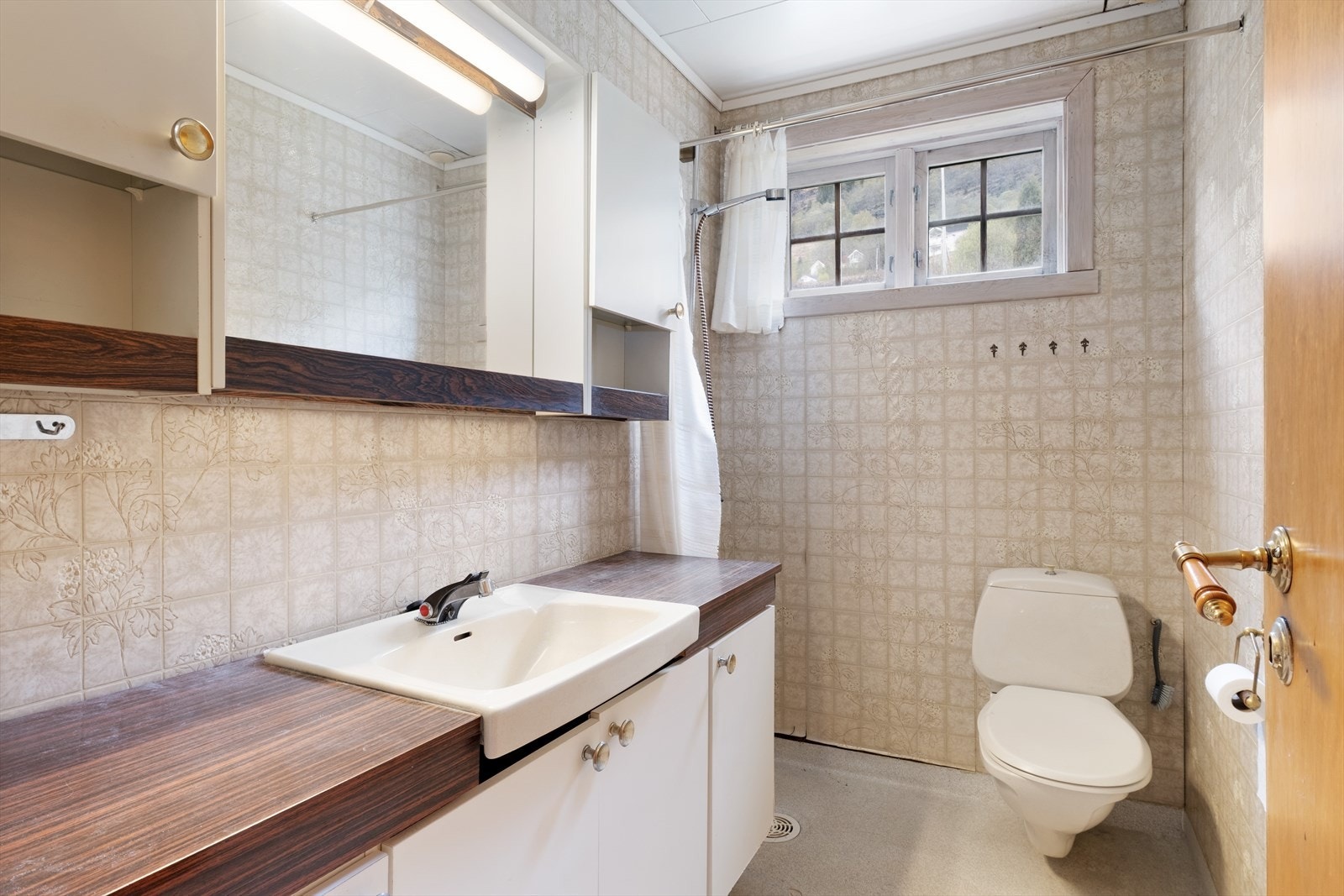 Badet har vinylbelegg på golv og veggar, og tak-ess-plater i taket. Galleribilde