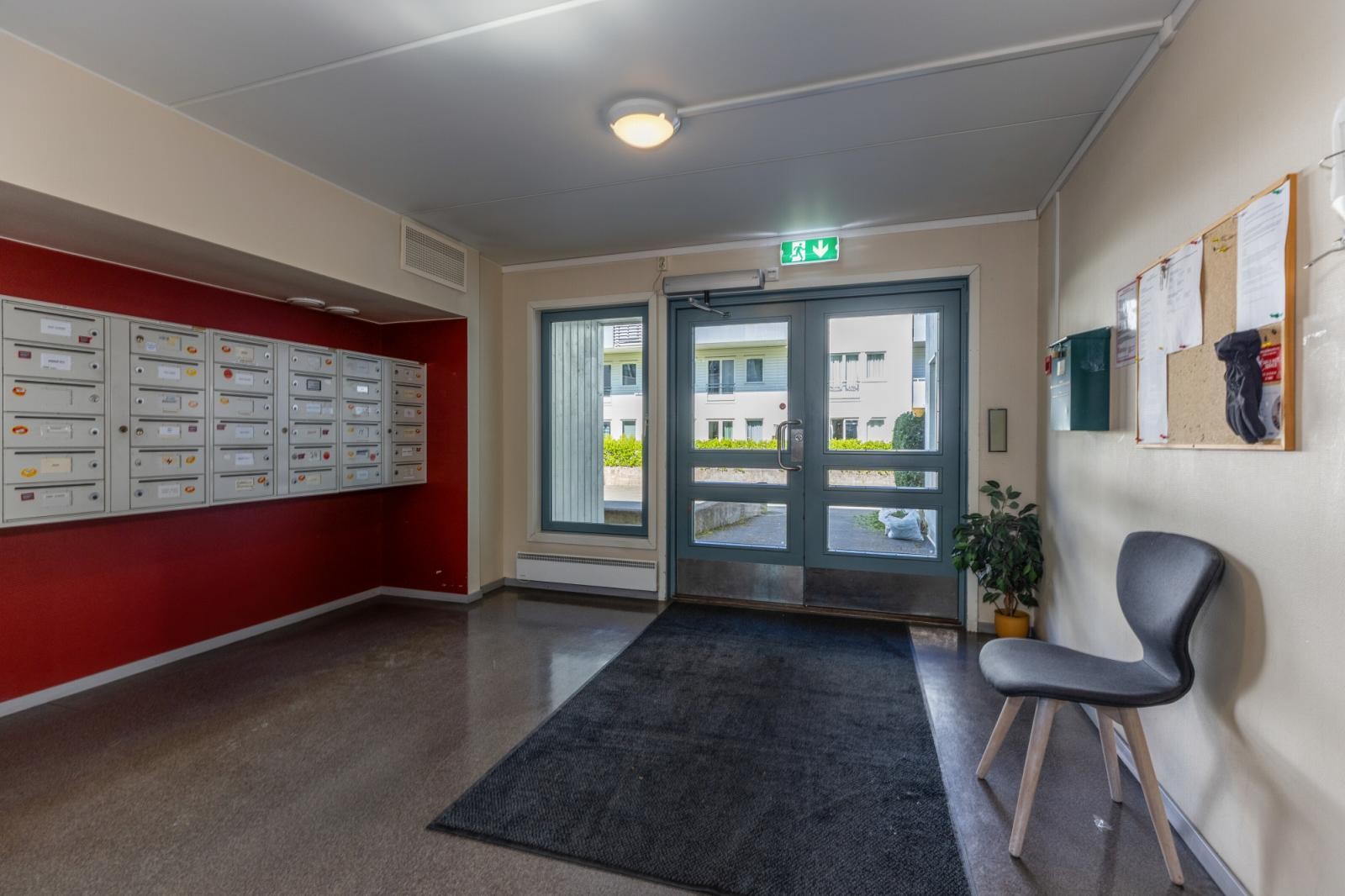 Inngangsparti med postkasser og informasjonstavle. Galleribilde