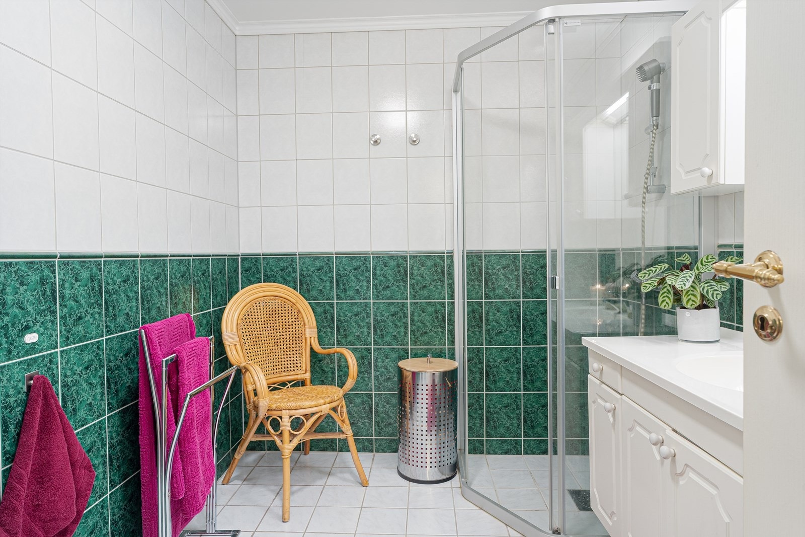Det er flott, helfliset bad i leiligheten med lyse fliser på gulv, varmekabler og grønne/lyse fliser på vegg. Videre har en på badet toalett (byttet i ca. 2018), dusjdører (byttet i ca. 2020). Galleribilde