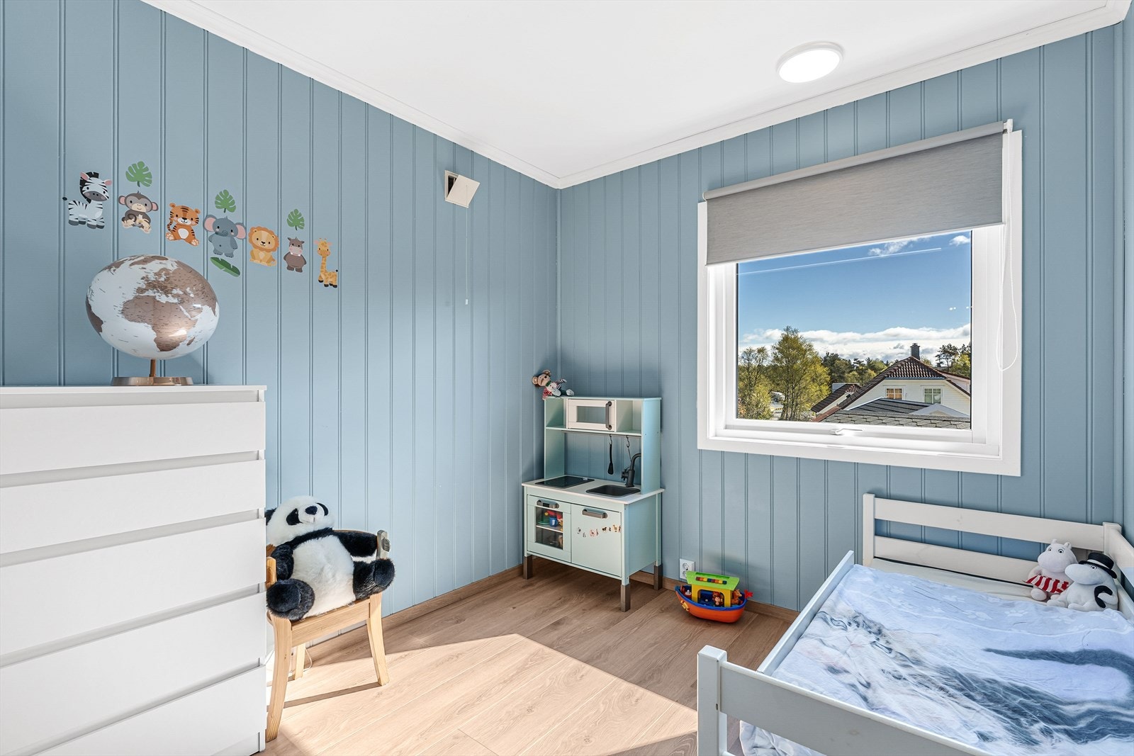 Soverom med laminatgulv og malte panelplater på veggene. Galleribilde