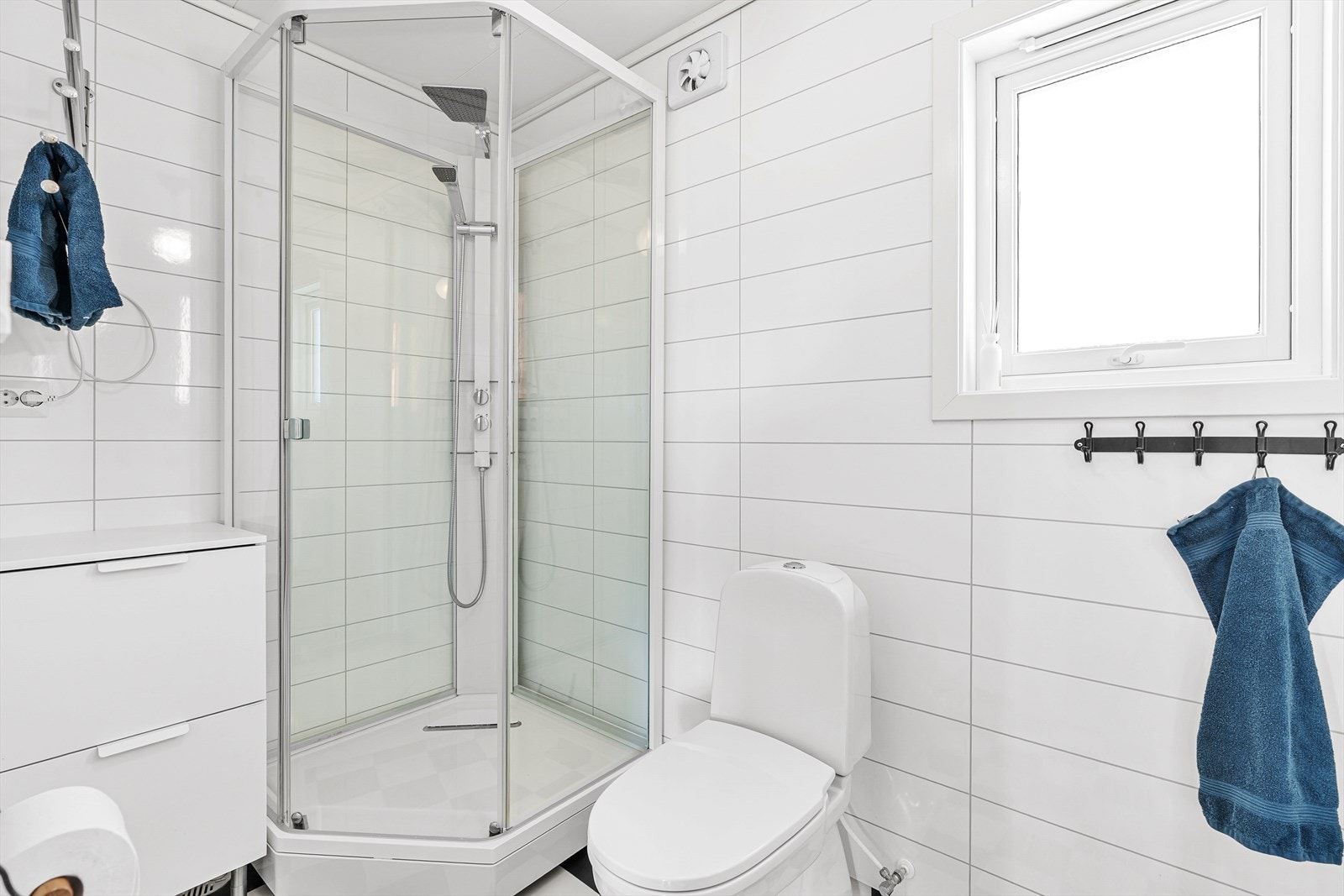 Badet er utstyrt med dusjkabinett, toalett og elektriske varmekabler i gulvet. Galleribilde