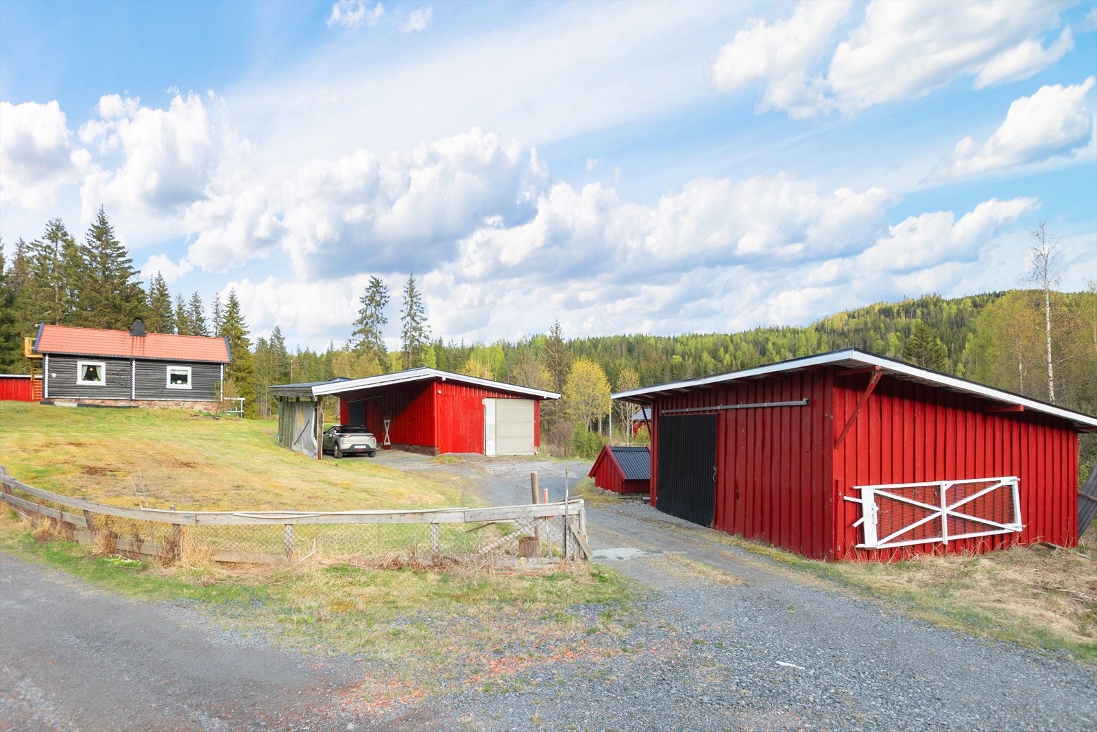 Eiendommen har en stor garasje på 77 m² og tre uthus, som gir rikelig med lagrings- og bruksmuligheter. Galleribilde