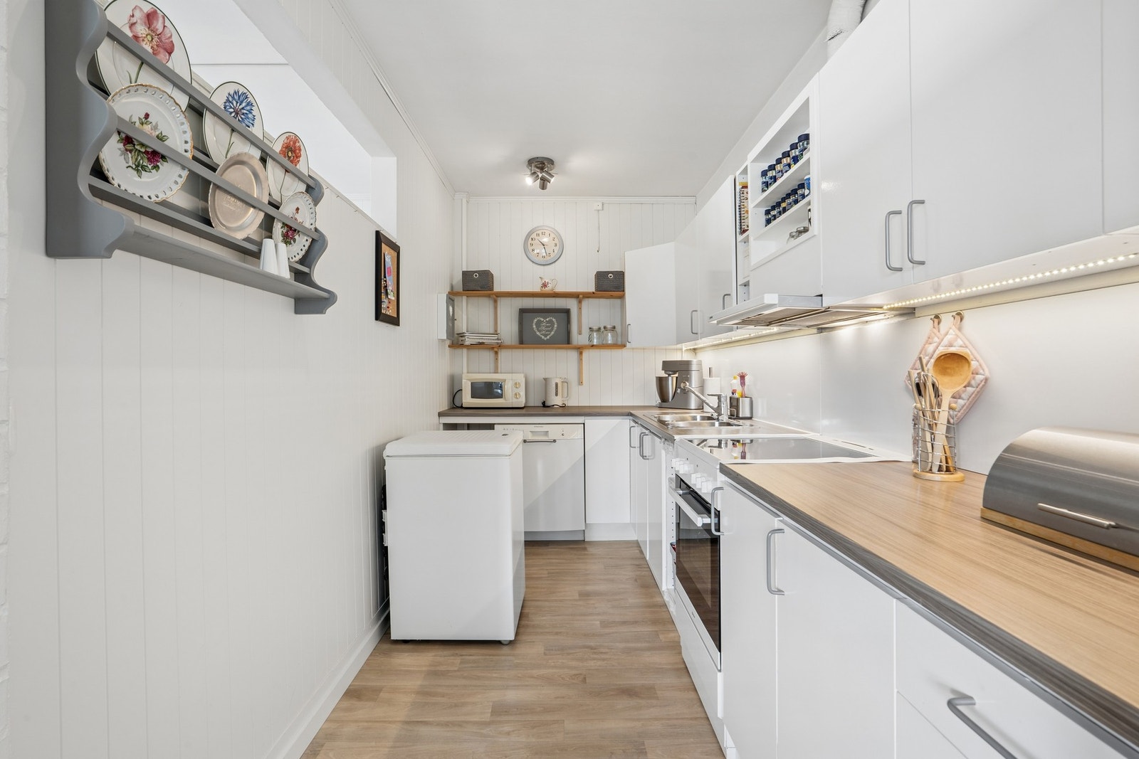 Kjøkkenet har frittstående hvitevarer, inkludert komfyr, oppvaskmaskin og kjøl/fryseskap. Galleribilde