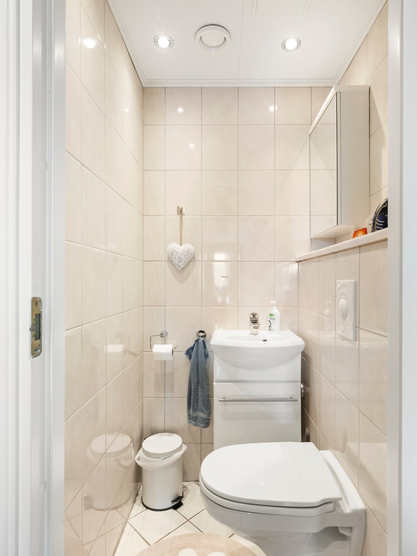 Separat WC/toalettrom med flislagte gulv og vegger og downlights i himling Galleribilde