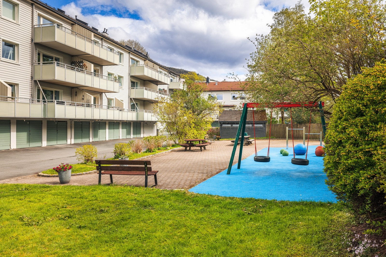 Stort fellesområde med grøntområde, benker og lekeplass. Galleribilde