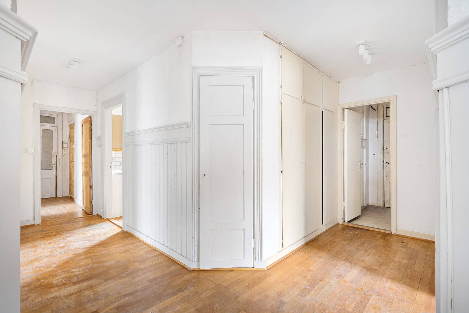 Lys og romslig entré med med to inngangsdører, én fra hvert trappeløp. Galleribilde