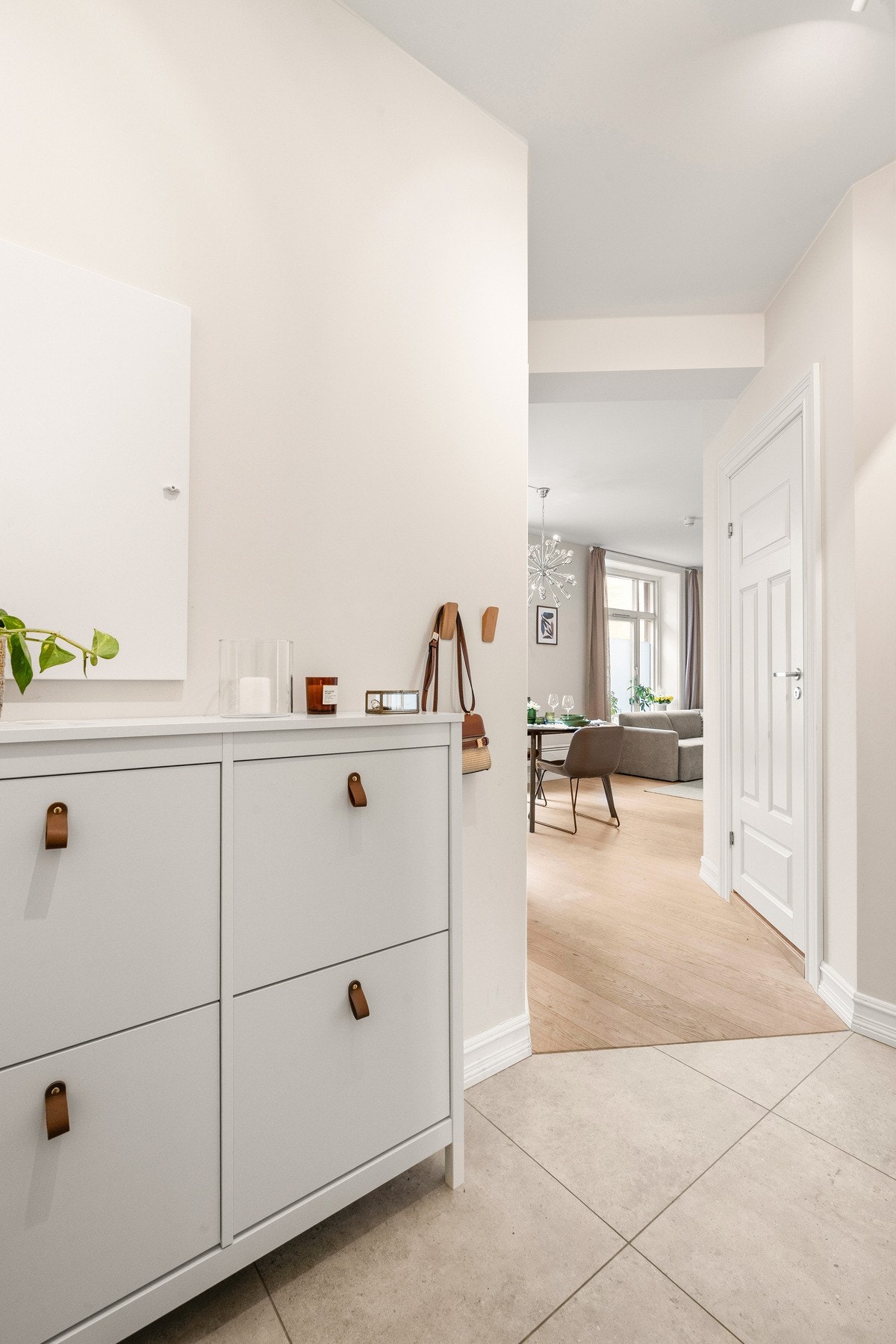 Entréen gir et godt førsteinntrykk av leiligheten med delikate, lysmalte vegger og store 60x60-fliser på gulv. Galleribilde