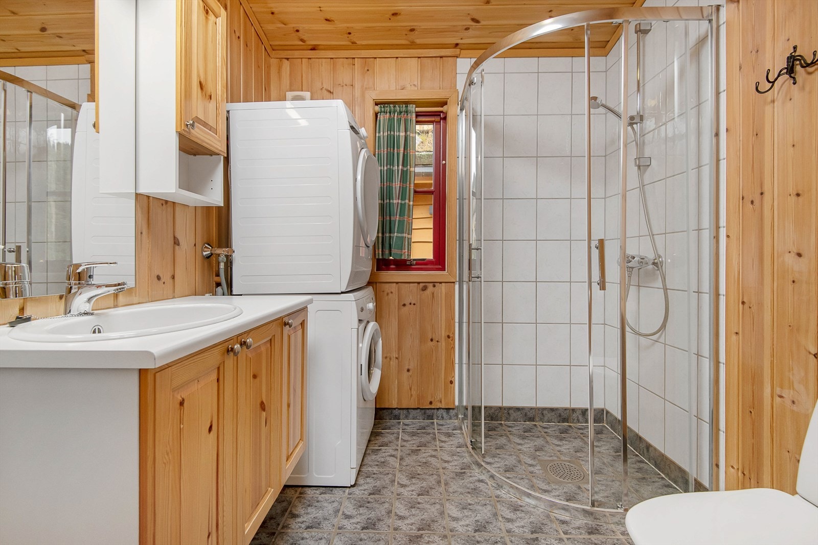 Pent og funksjonelt bad/WC har dusjvegger, servantinnredning og vaskesøyle. Galleribilde