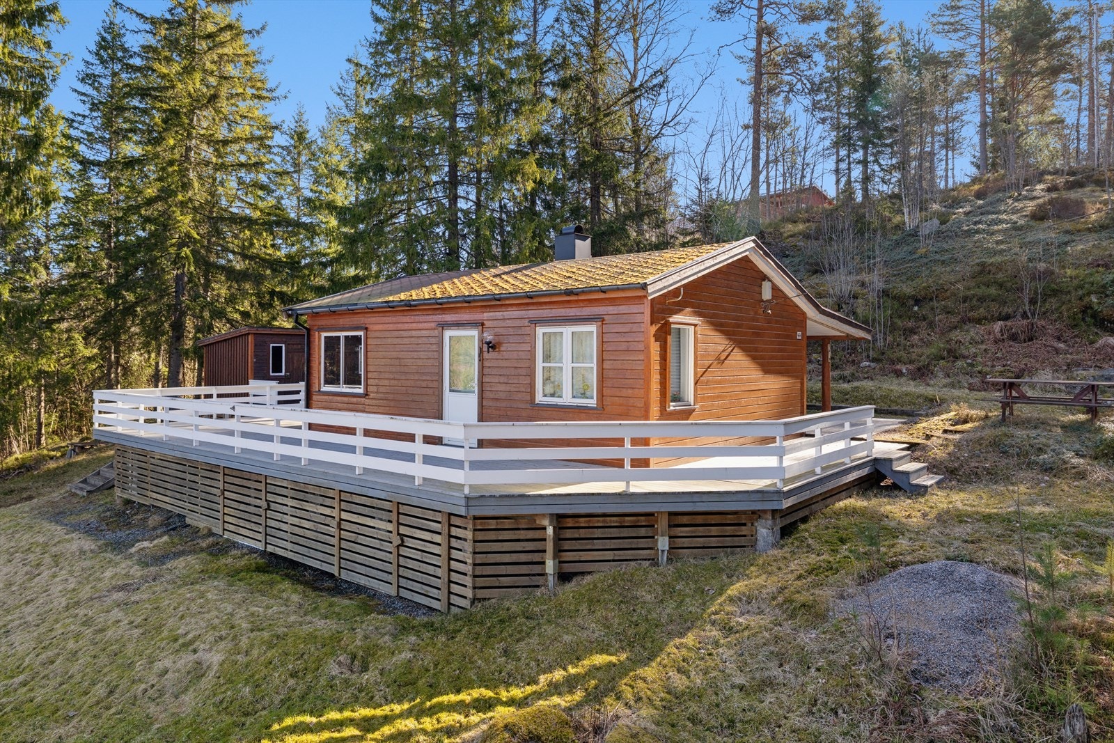 Velkommen til denne sjarmerende hytta med en stor, omkransende terrasse og naturtomt. Galleribilde