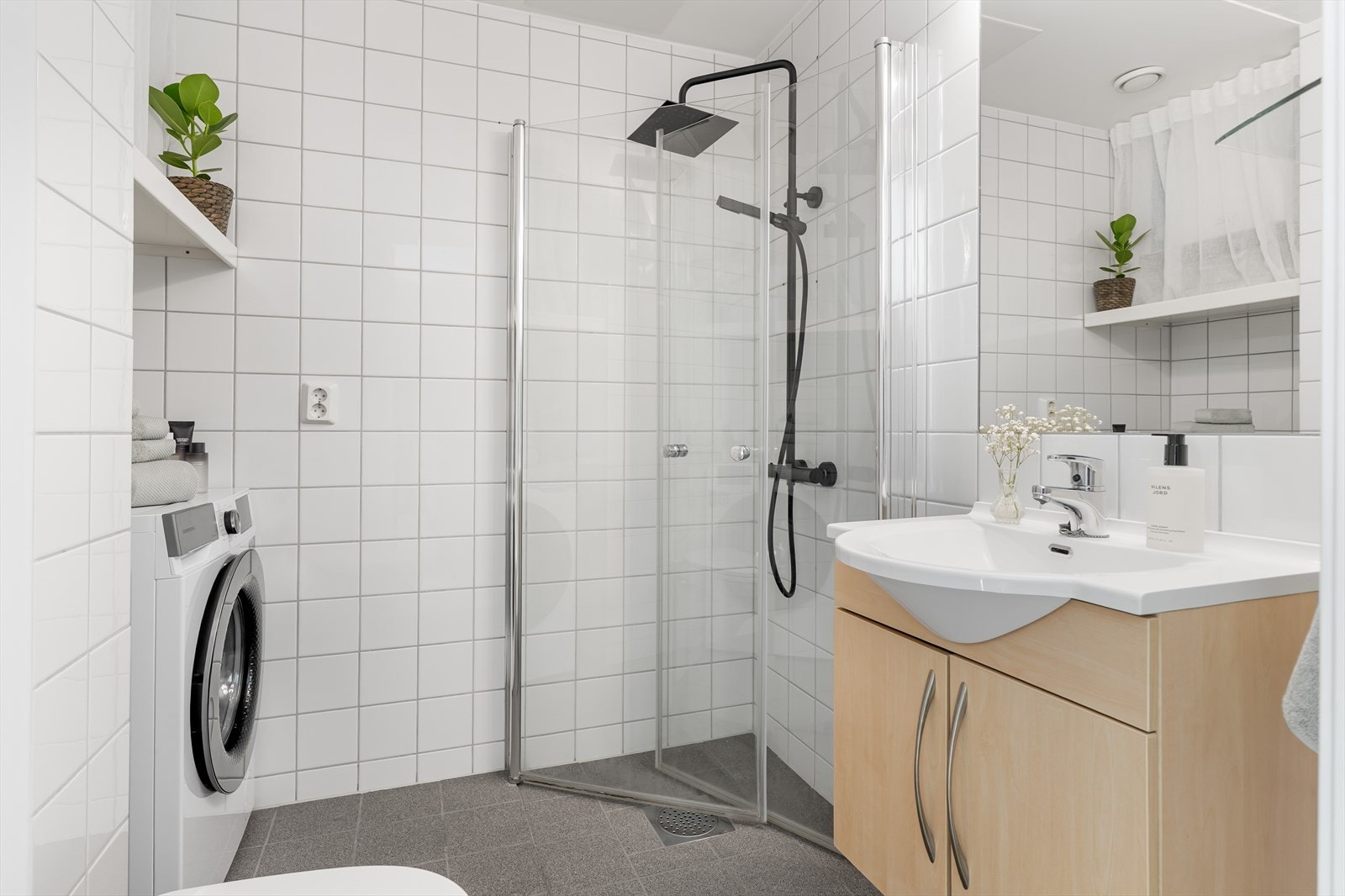 Pent og flislagt baderom med god plass til vaskemaskin. Galleribilde