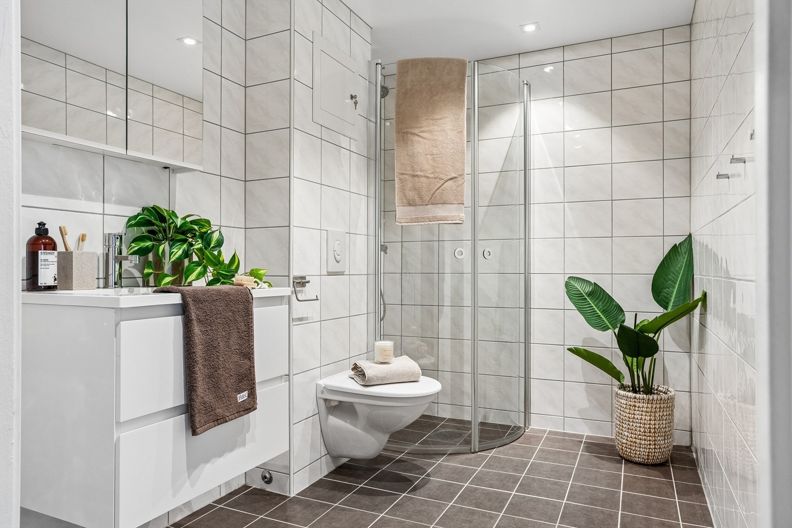 Bad fra 2015 med keramiske fliser, vegghengt toalett og opplegg for vaskemaskin. Galleribilde