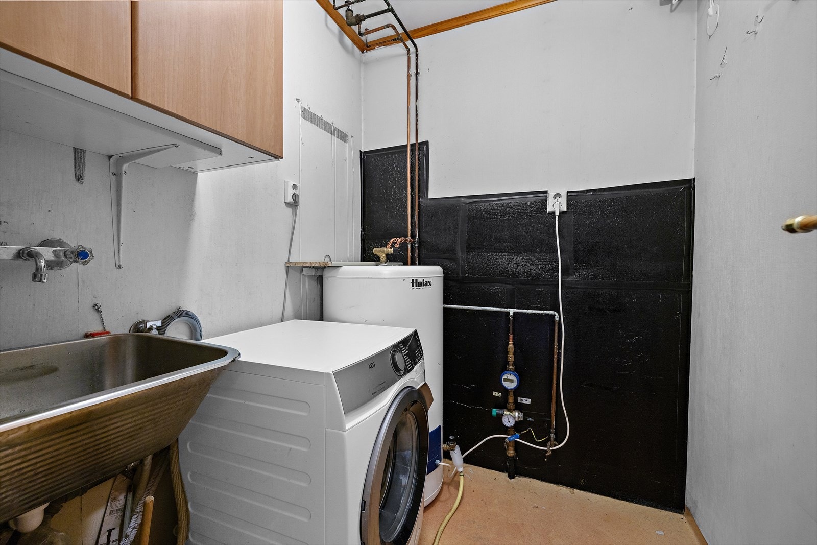 Praktisk, separat vaskerom med utslagsvask, opplegg for vaskemaskin og mekanisk avtrekk. Galleribilde