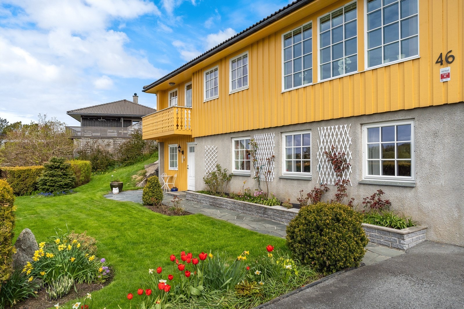 Eiendommen har en pent opparbeidet hage og integrert garasje i underetasjen. Galleribilde