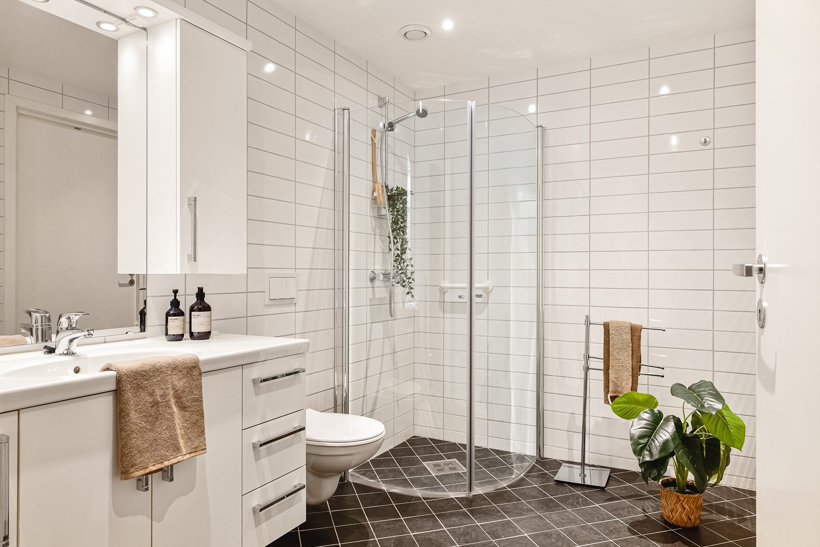 Hovedbadet har flislagt gulv med varmekabler, downlights i taket og vegghengt toalett. Galleribilde