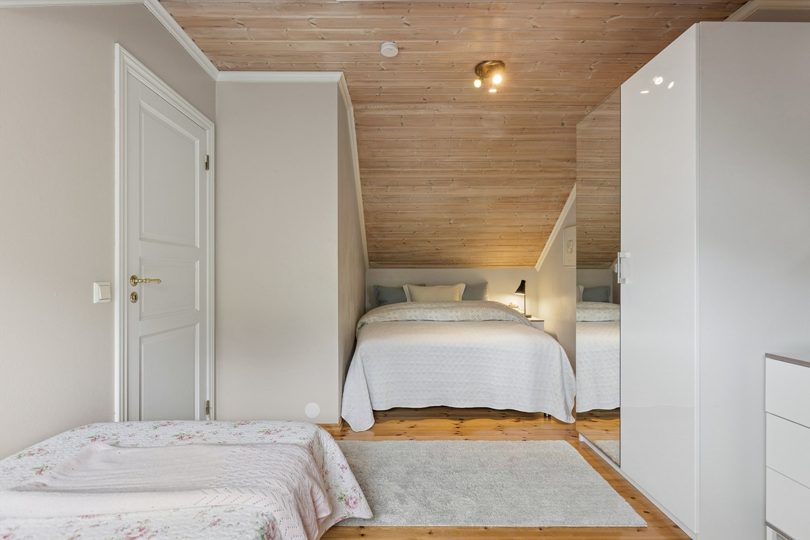 Soverom med skråtak som gir rommet et lunt preg. Plass til seng i nisje og garderobeløsning med speildører som bidrar til økt romfølelse. Galleribilde