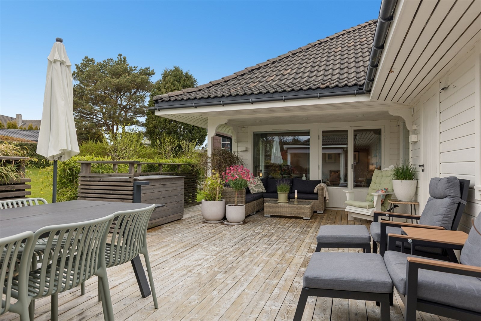 Lun og skjermet terrasse med overbygd del og flere sittegrupper. God plass til både spisebord og sofakrok, med direkte adkomst fra stuen. Galleribilde