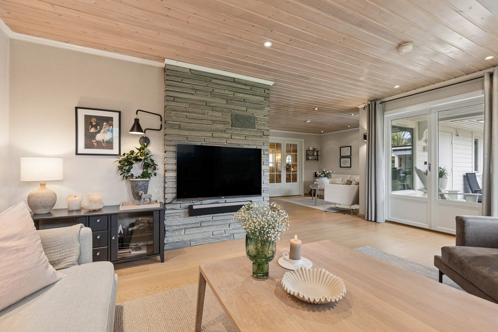 Stuen vender mot uteplassen og har direkte utgang via skyvedør. Den markerte peisveggen gir rommet karakter og skaper en naturlig soneinndeling. Galleribilde