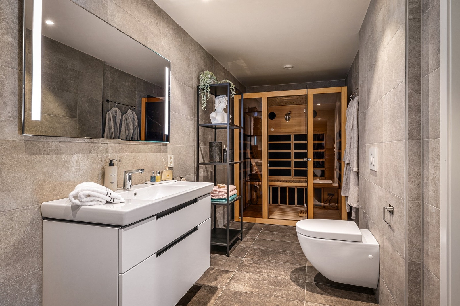 Egen badstu og dusjnisje i glass gir badet en eksklusiv og spa-lignende atmosfær Galleribilde