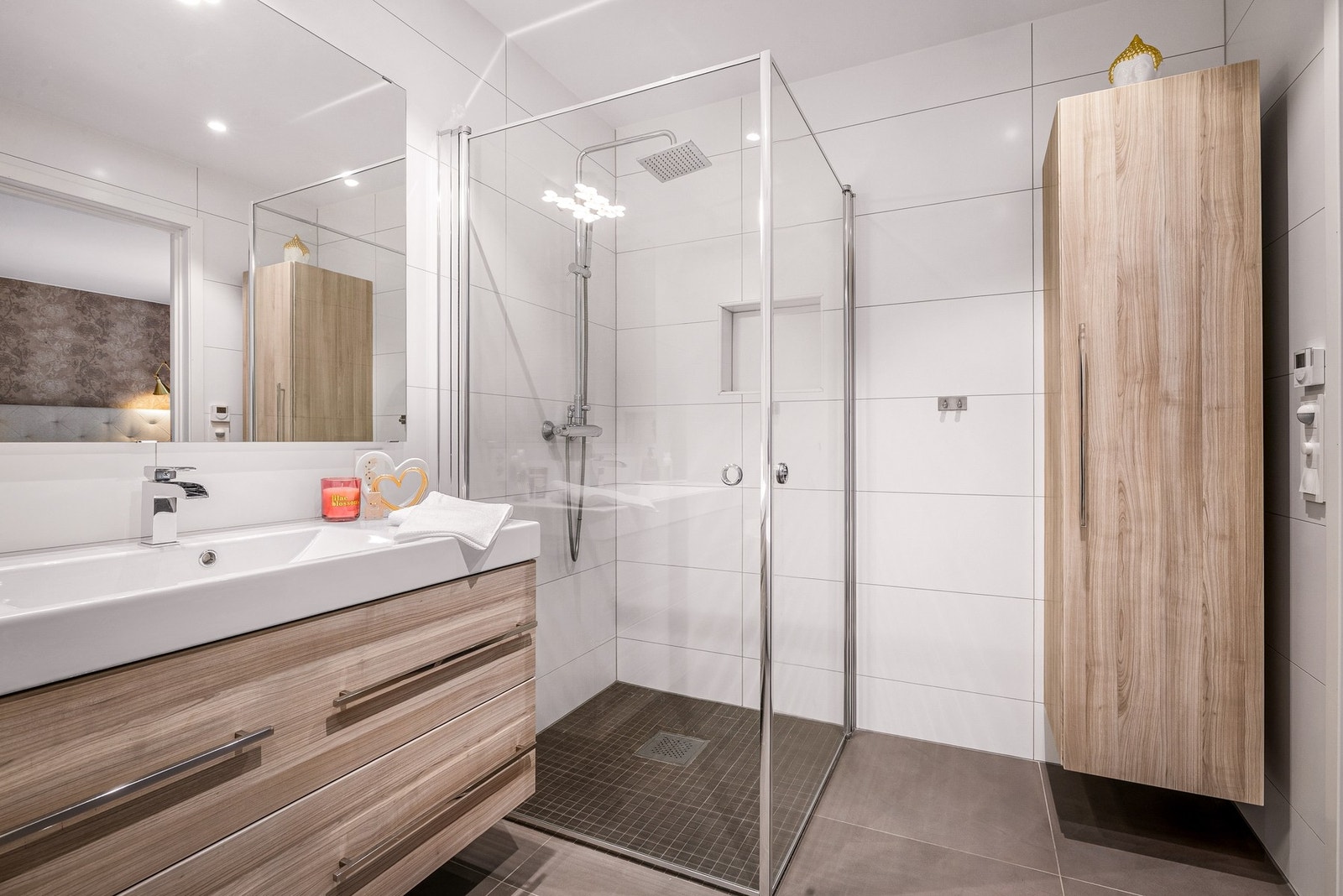 Badet holder en høy standard med moderne materialvalg, badekar og dusjhjørne i glas Galleribilde