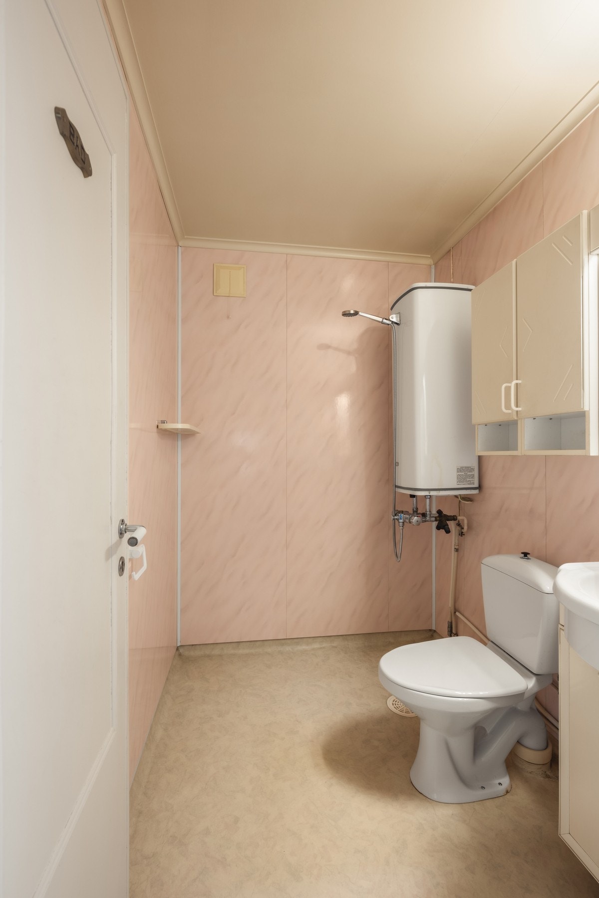 Badet har enkel standard med dusj montert ved veggbereder, baderomsplater på vegger, gulvbelegg og plastsluk. Galleribilde