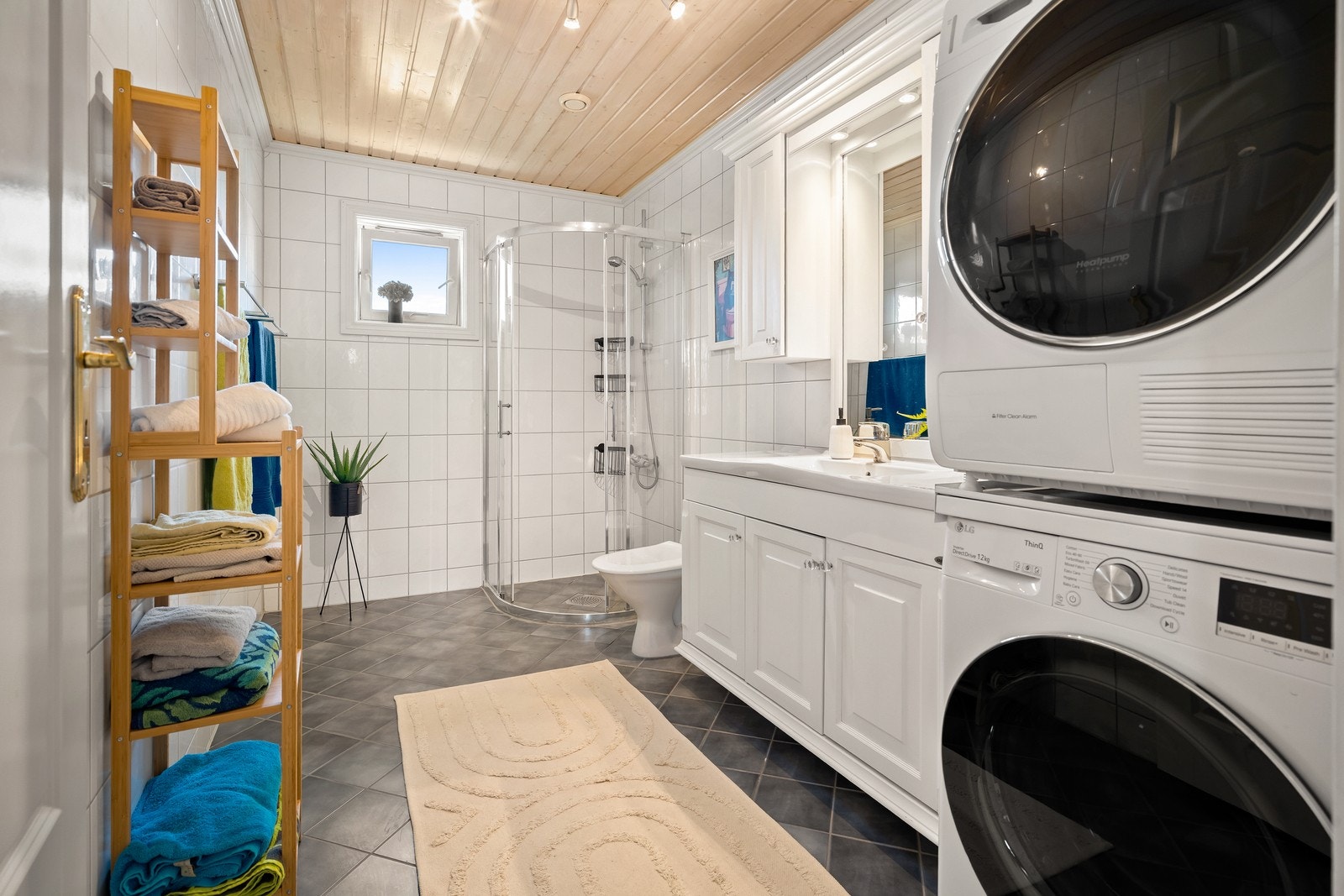 Badet er kombinert vaskerom med opplegg for vaskemaskin og har vannbåren gulvvarme. Galleribilde