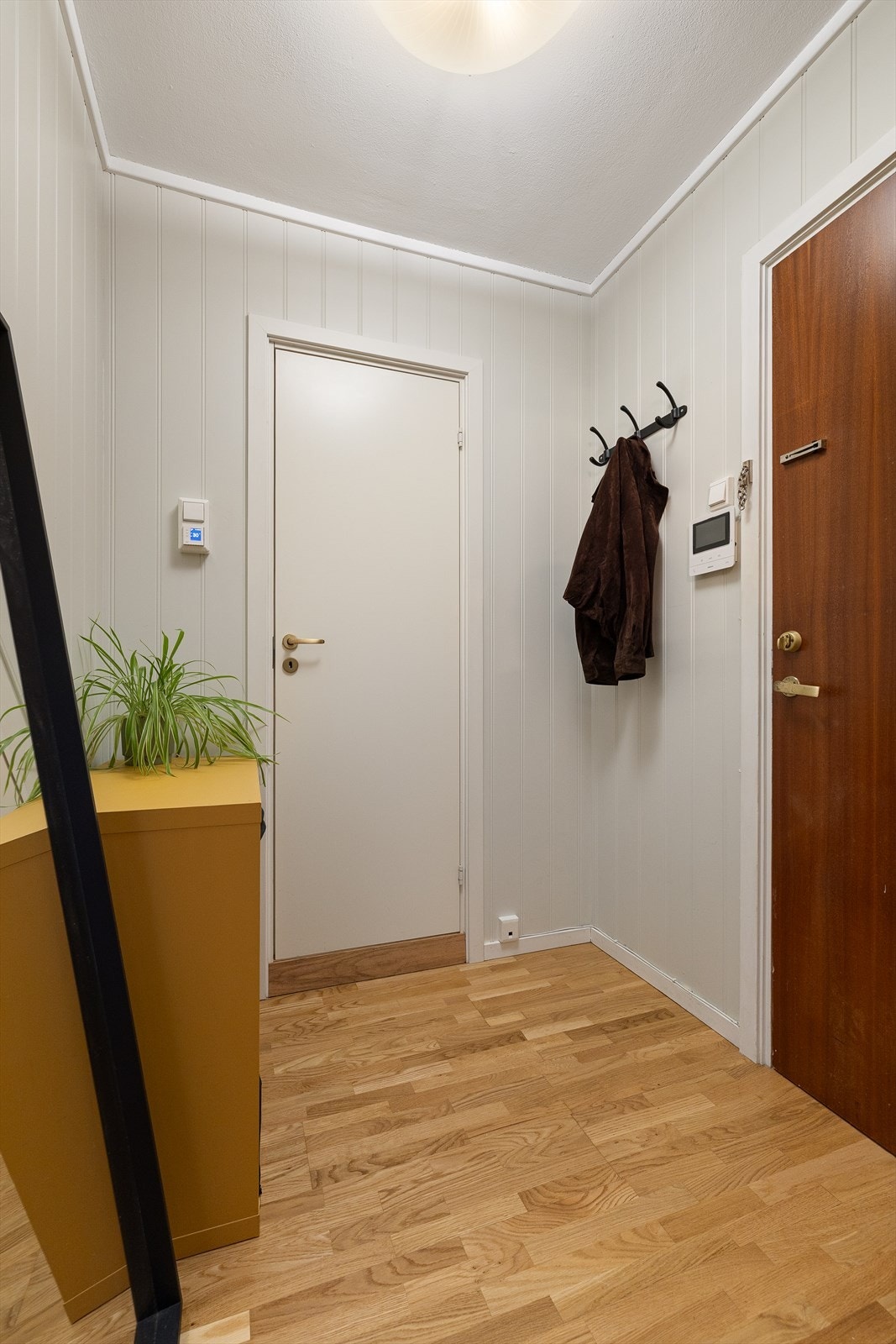 Velkommen inn! Gangen er innredet med både skap og kommode som gir gode oppbevaringsmuligheter for yttertøy og sko. Galleribilde