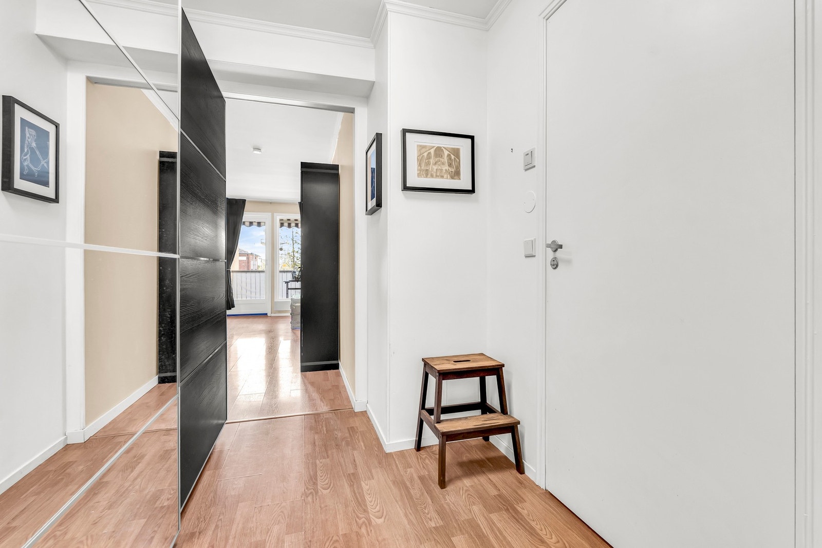 Lys gang, som leder inn til stue med store vinduer. Galleribilde