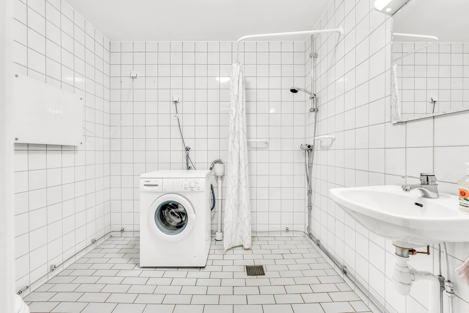 Flislagt bad med dusj, servant og vaskemaskin. Galleribilde