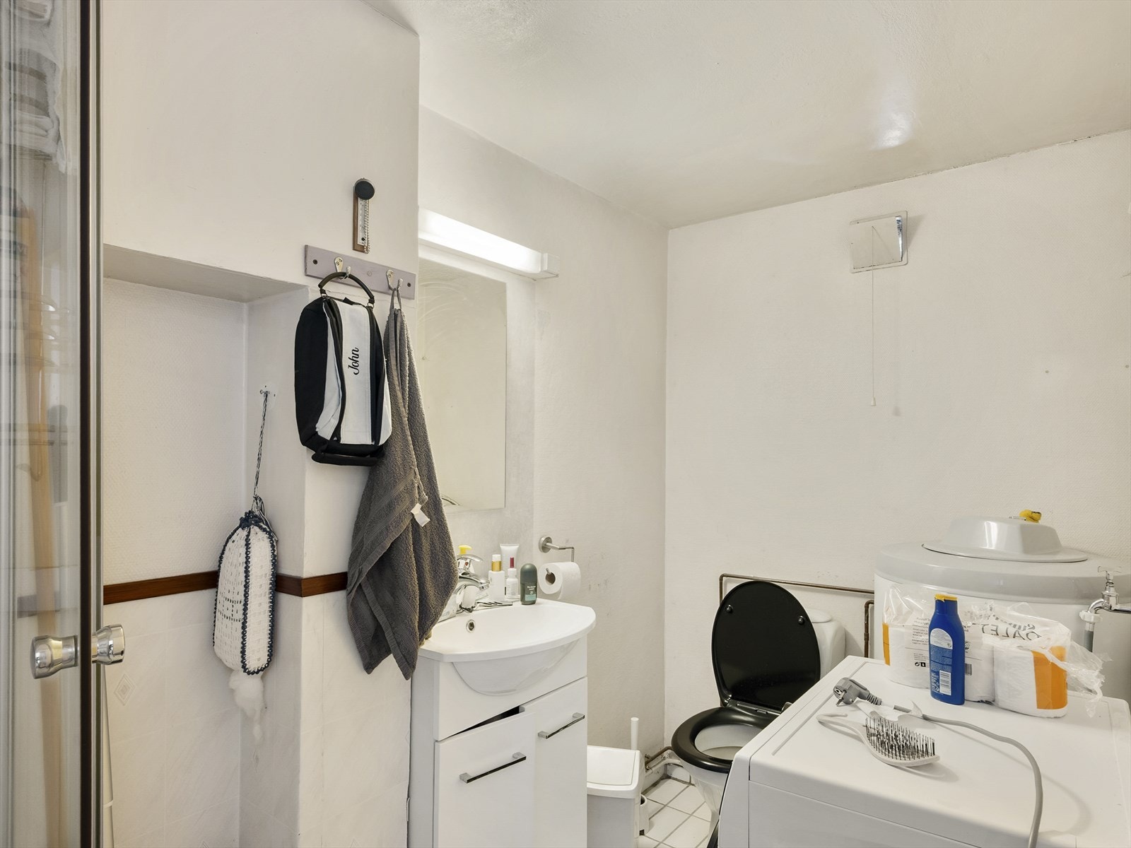 Badet er utstyrt med dusjkabinett, gulvstående toalett, servant og opplegg for vaskemaskin. Galleribilde
