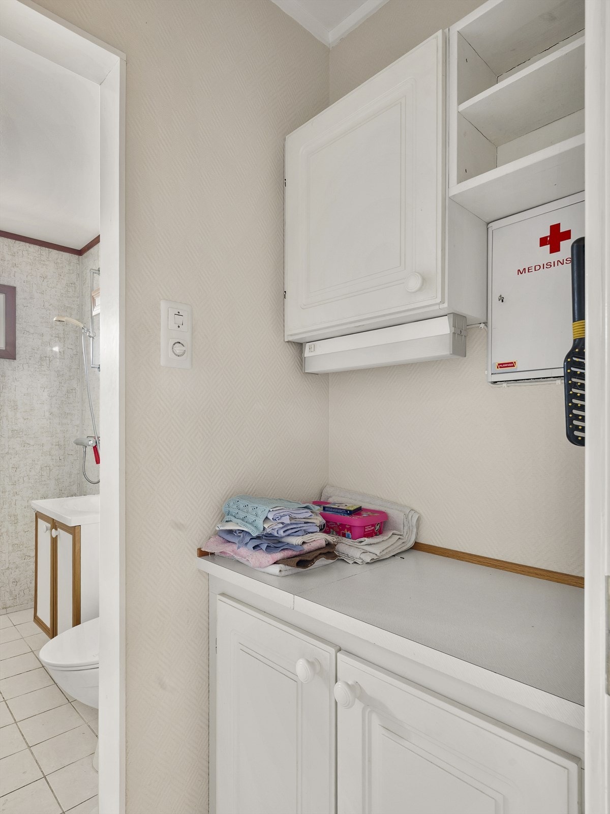 Praktisk mellomgang med oppbevaringsplass i tilknytning til badet. Galleribilde