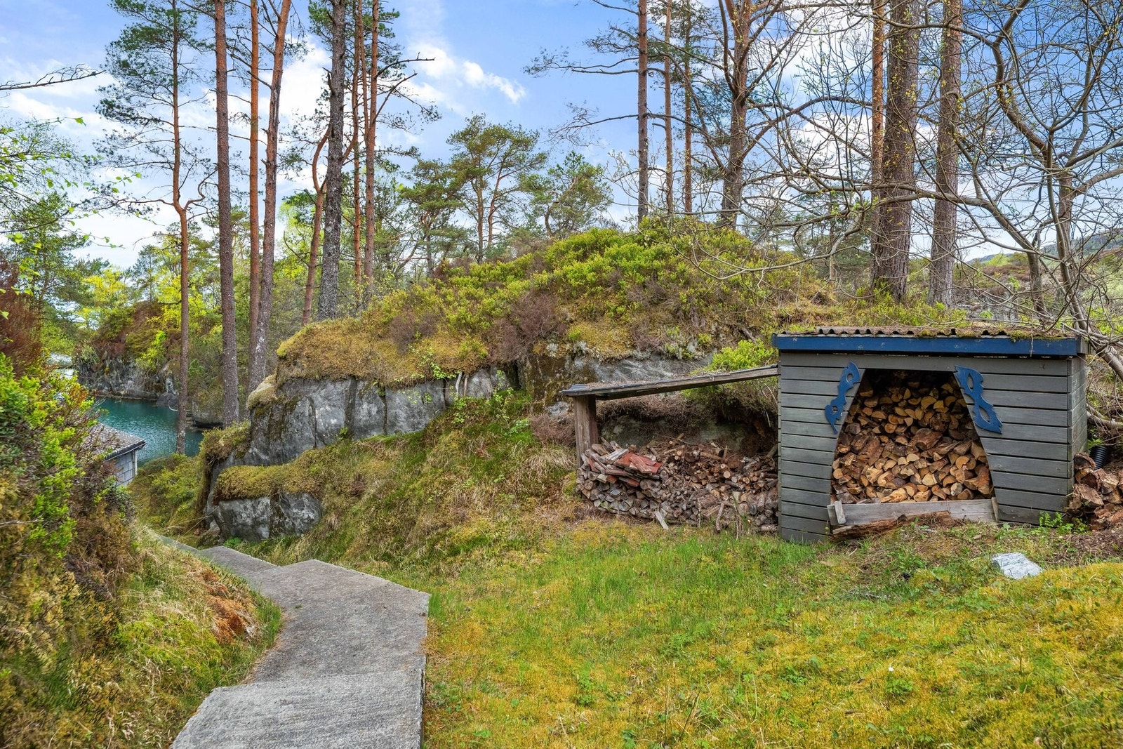 Praktisk vedlagring på eiendommen. Stien strekker seg videre ned mot kaiområdet. Galleribilde