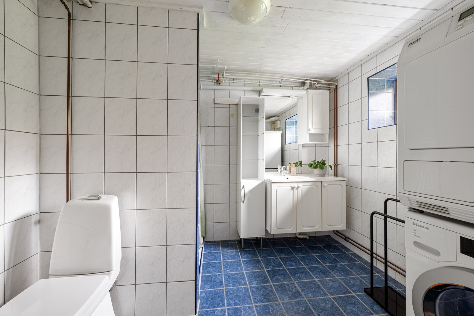 Flislagt bad i kjeller med servant, dusj, toalett og opplegg for vaskemaskin/tørketrommel. Galleribilde