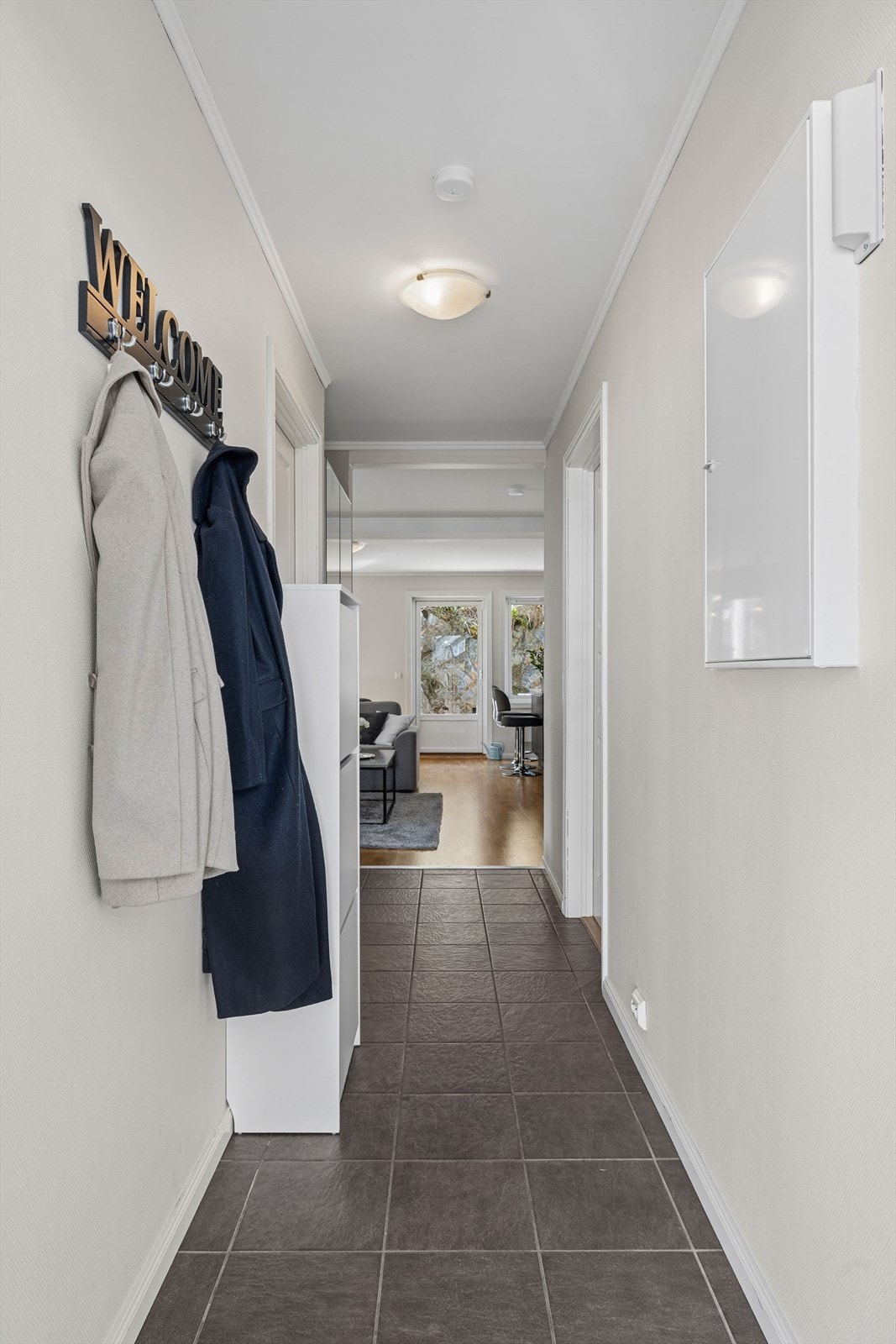 Gangen leder rett frem mot stuen, og dagslyset fra de store vinduene i stue og spisestue trekker blikket innover. Galleribilde