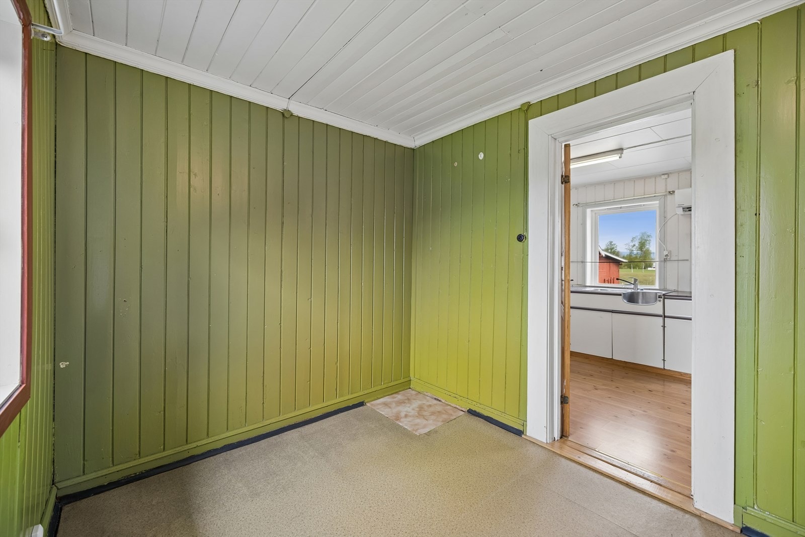 Soverom med panelvegger og vindu mot tunet. Rommet har behov for modernisering. Galleribilde