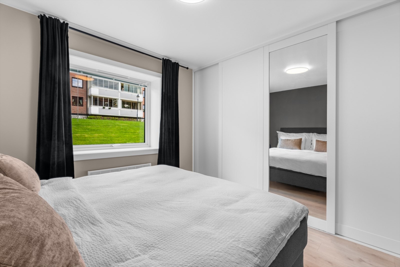 Det er montert en stor skyvedørsgarderobe med glatte fronter og speil. Galleribilde