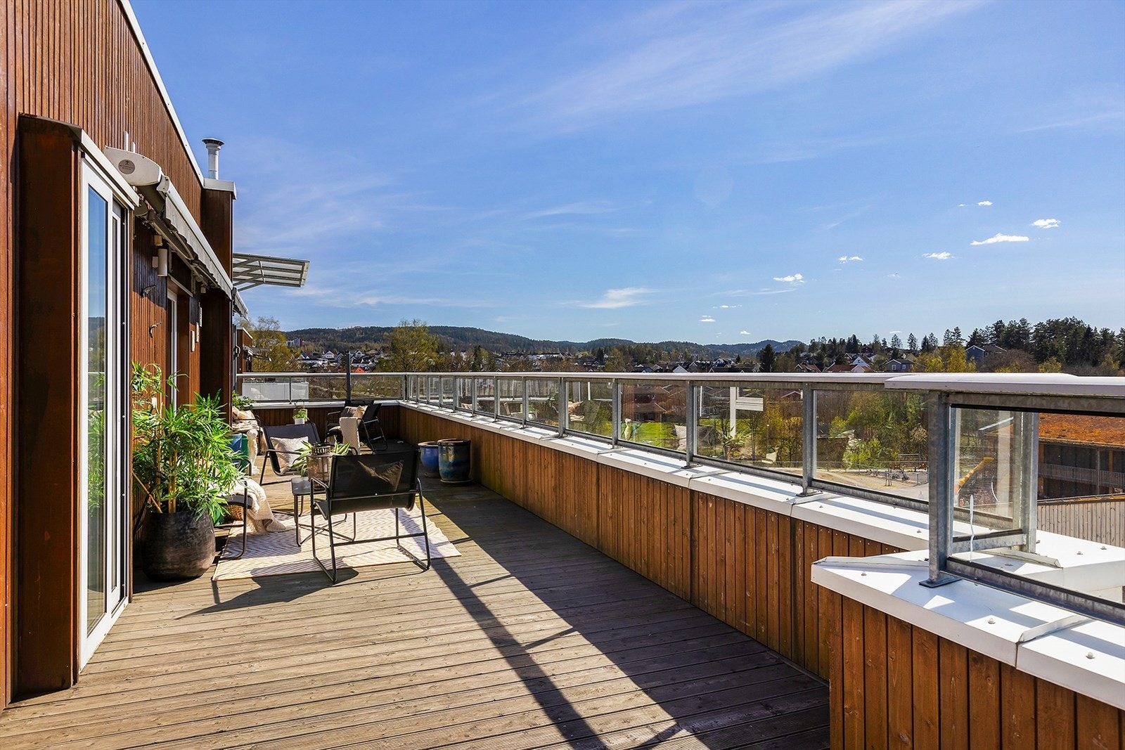 Solrik terrasse med skjermet rekkverk og utsyn mot nærområdet Galleribilde