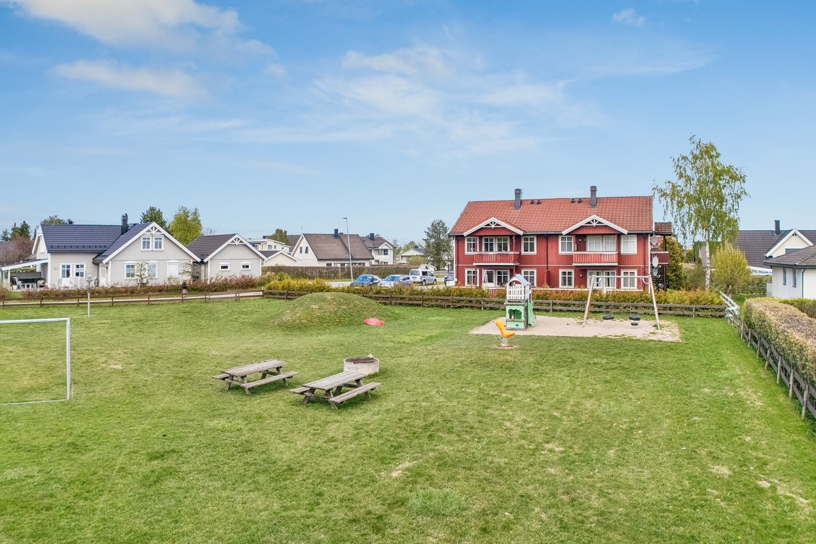 Sameiets felles tomt er pent opparbeidet med plen, beplantning og lekeapparater. Galleribilde