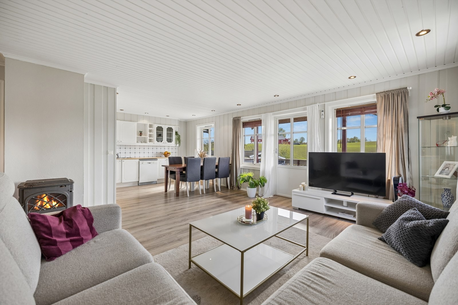 Åpen løsningen mellom stue og kjøkken skaper en sosial og luftig sone med plass til både sofagruppe og spisebord. Galleribilde